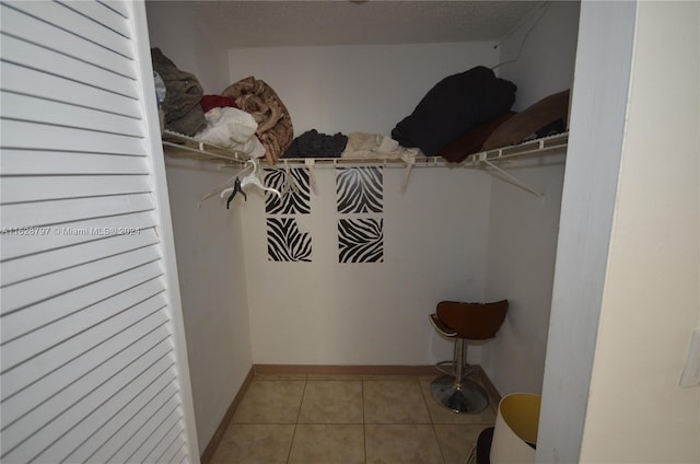 walk in closet with light tile patterned floors