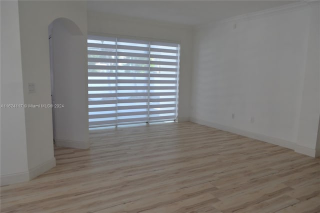 unfurnished room featuring crown molding and hardwood / wood-style floors