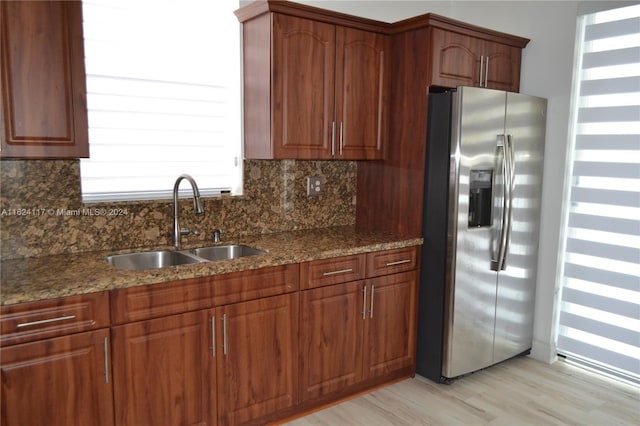 kitchen with sink, decorative backsplash, light hardwood / wood-style floors, and stainless steel fridge with ice dispenser