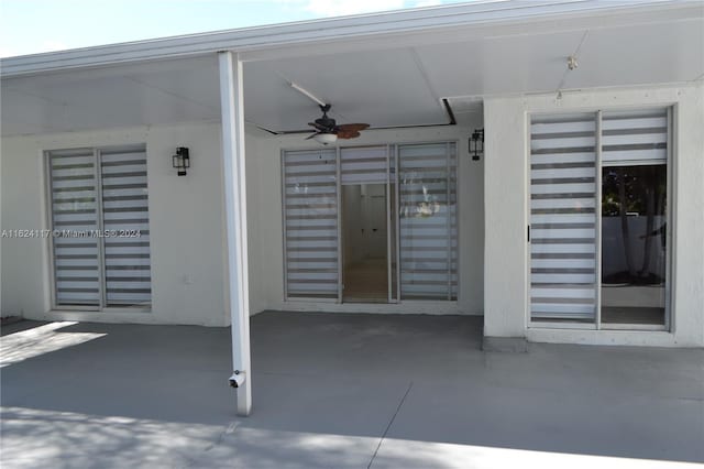 entrance to property featuring ceiling fan and a patio area