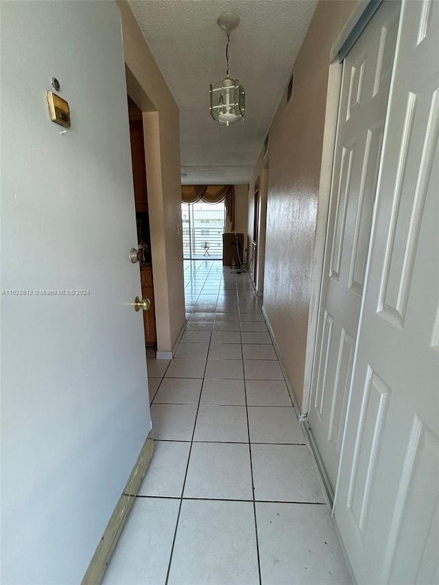 3600 NE 170th St Unit 411, North Miami Beach, FL 33160 - hallway featuring light tile patterned floors and baseboards