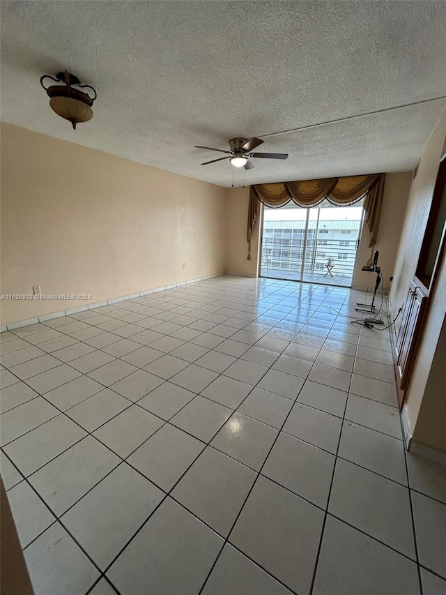 unfurnished room featuring a textured ceiling, ceiling fan, and light tile patterned floors