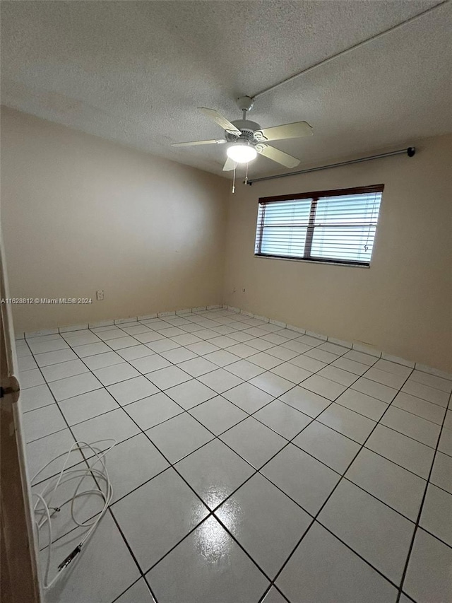 unfurnished room with light tile patterned flooring, a textured ceiling, and ceiling fan