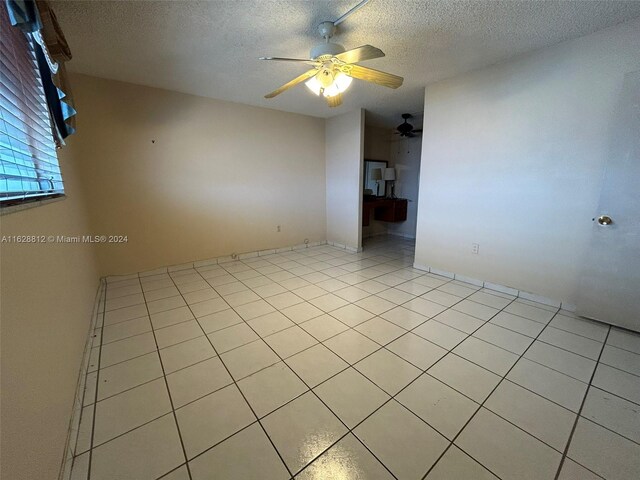 3600 NE 170th St Unit 411, North Miami Beach, FL 33160 - spare room featuring a ceiling fan, a textured ceiling, and light tile patterned flooring