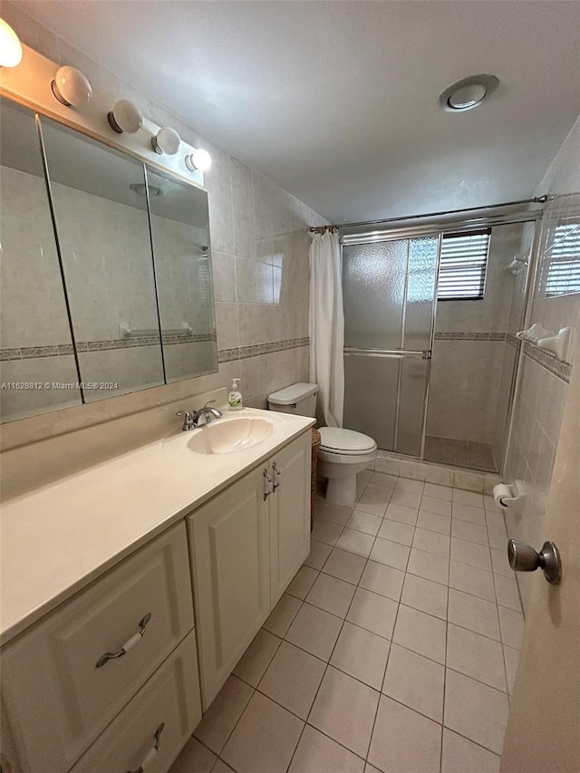 3600 NE 170th St Unit 411, North Miami Beach, FL 33160 - bathroom featuring a shower stall, tile patterned floors, vanity, toilet, and tile walls