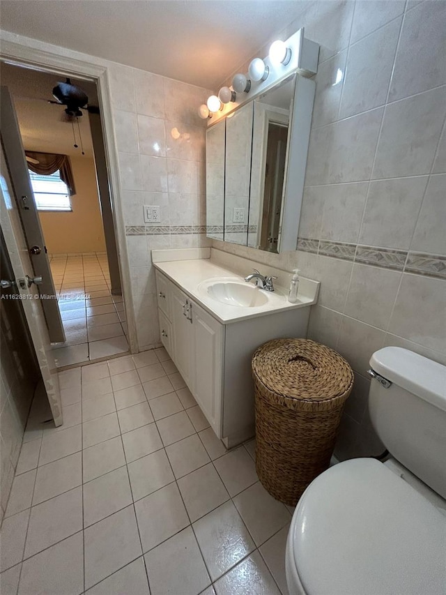 bathroom with vanity, tile walls, toilet, and tile patterned flooring