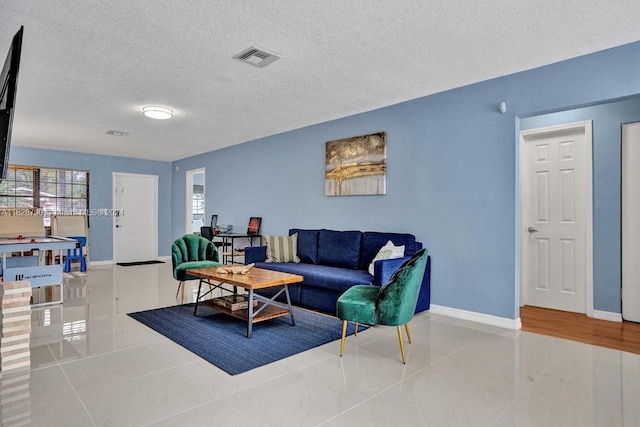 208 SW 2nd Ave, Hallandale Beach, FL 33009 - living area with a textured ceiling and tile patterned flooring