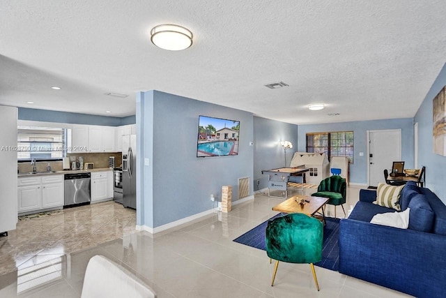 208 SW 2nd Ave, Hallandale Beach, FL 33009 - living area with healthy amount of natural light, light tile patterned floors, and a textured ceiling