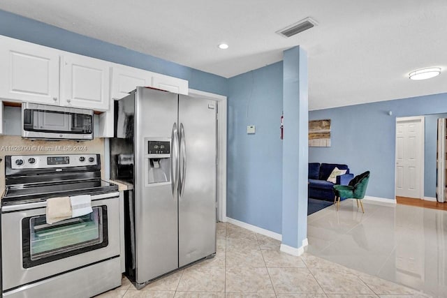 208 SW 2nd Ave, Hallandale Beach, FL 33009 - kitchen featuring stainless steel appliances, white cabinets, light tile patterned flooring, and recessed lighting