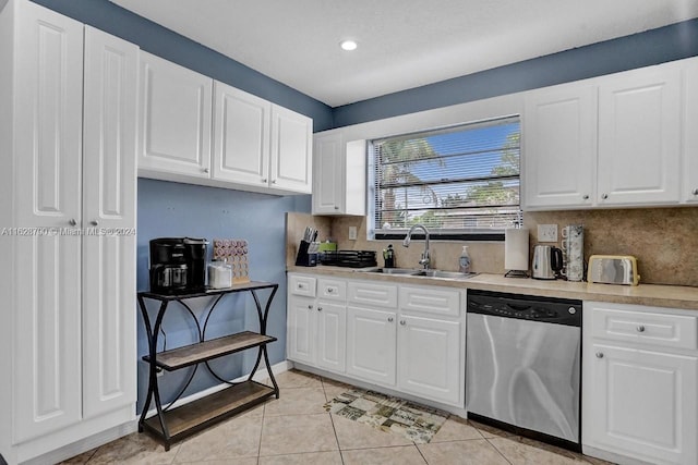 208 SW 2nd Ave, Hallandale Beach, FL 33009 - kitchen featuring stainless steel dishwasher, backsplash, light countertops, light tile patterned flooring, and white cabinetry