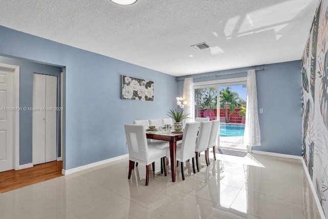208 SW 2nd Ave, Hallandale Beach, FL 33009 - dining room with a textured ceiling and light tile patterned flooring