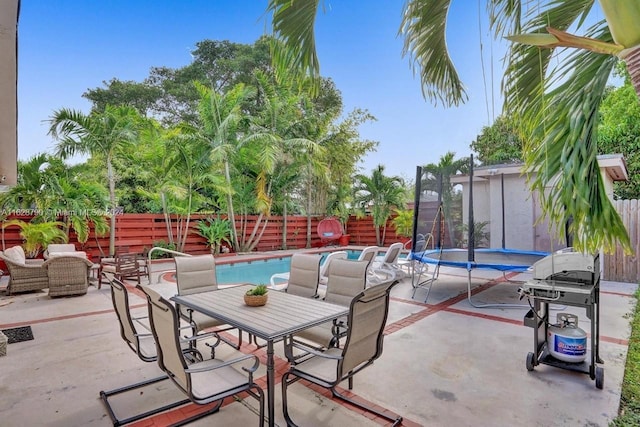 208 SW 2nd Ave, Hallandale Beach, FL 33009 - fenced backyard with a trampoline, a patio, outdoor dining space, and a grill