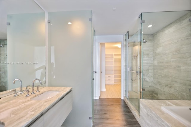 bathroom featuring vanity, wood-type flooring, and walk in shower