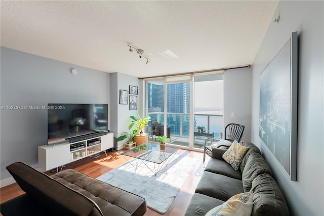 living room featuring hardwood / wood-style floors, expansive windows, a textured ceiling, and rail lighting