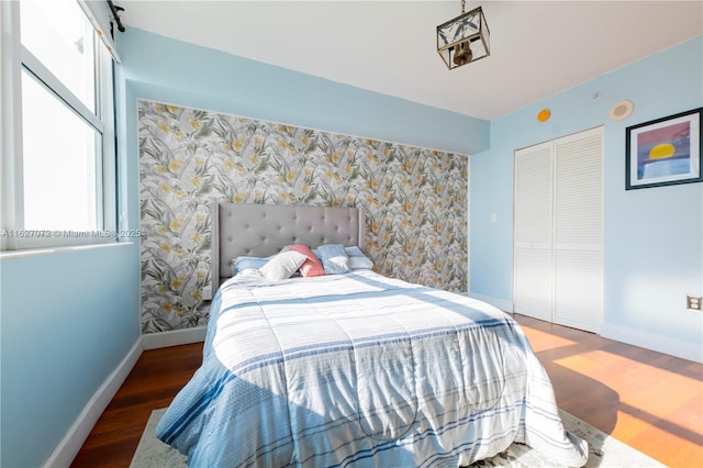 bedroom with dark hardwood / wood-style floors and a closet