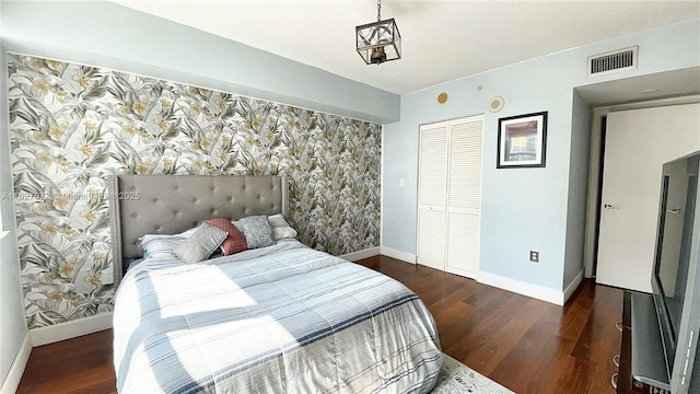 bedroom with dark hardwood / wood-style flooring and a closet