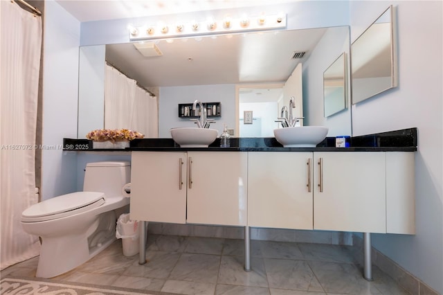 bathroom featuring tile patterned floors, vanity, and toilet