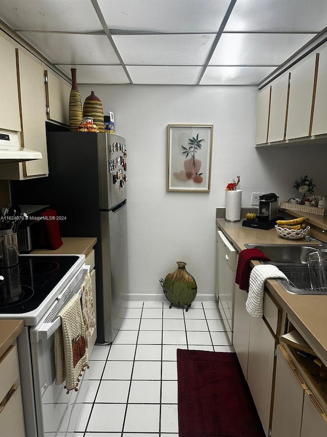 kitchen with stove, exhaust hood, a paneled ceiling, dishwasher, and light tile patterned floors