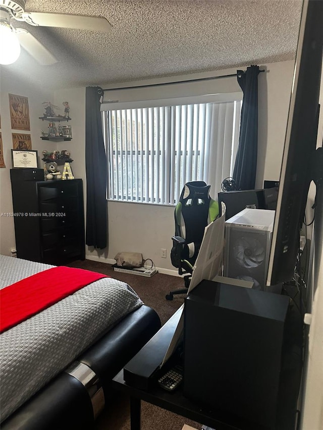 bedroom with ceiling fan, carpet floors, and a textured ceiling