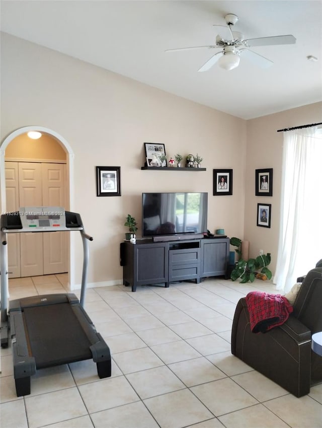 workout area featuring light tile patterned flooring, lofted ceiling, and ceiling fan