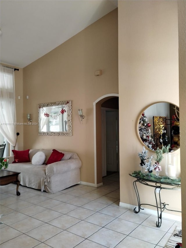 living room featuring light tile patterned floors and high vaulted ceiling