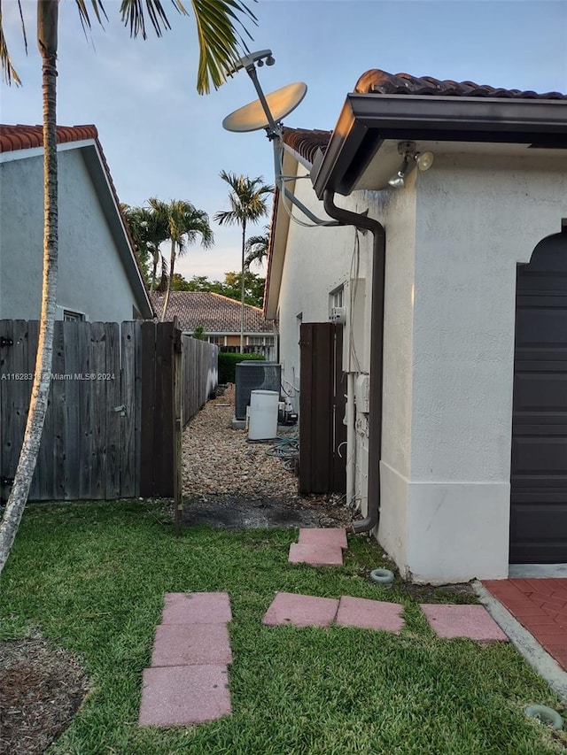 view of side of home with cooling unit and a lawn