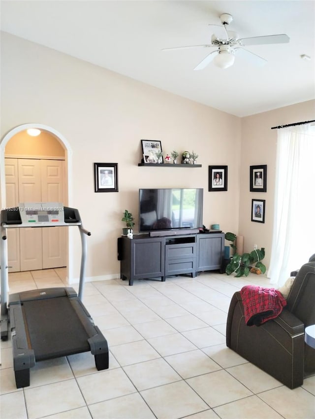 workout area featuring lofted ceiling, light tile patterned floors, and ceiling fan