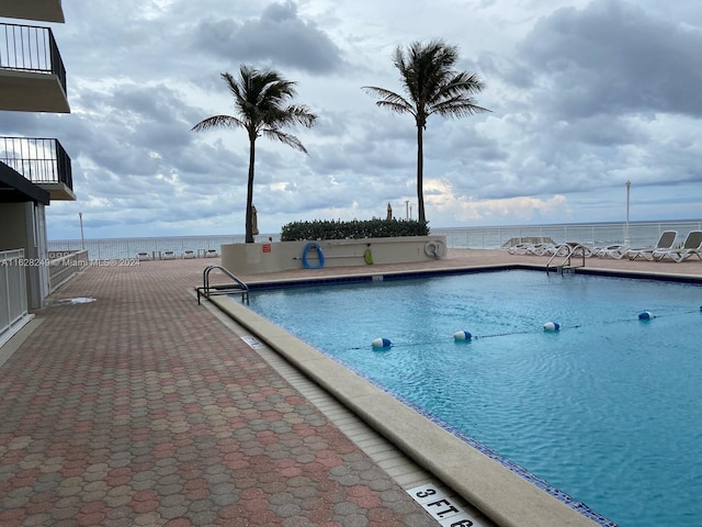 view of swimming pool with a water view