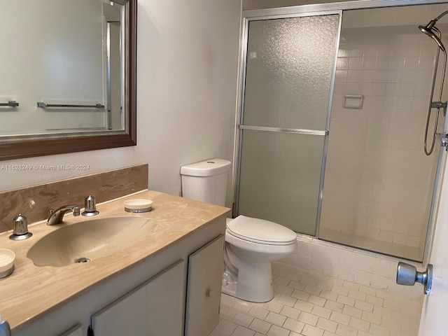 bathroom featuring an enclosed shower, tile patterned floors, toilet, and vanity