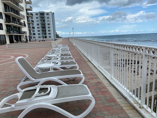 surrounding community with a water view and a view of the beach