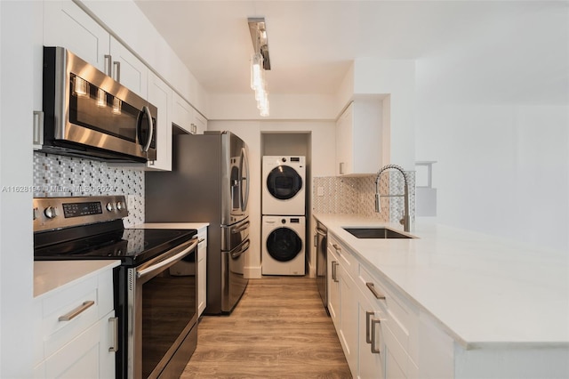 kitchen featuring sink, decorative backsplash, stainless steel appliances, and white cabinetry