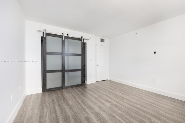 interior space with wood-type flooring and a barn door