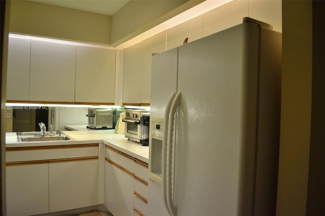 kitchen featuring sink and white refrigerator with ice dispenser