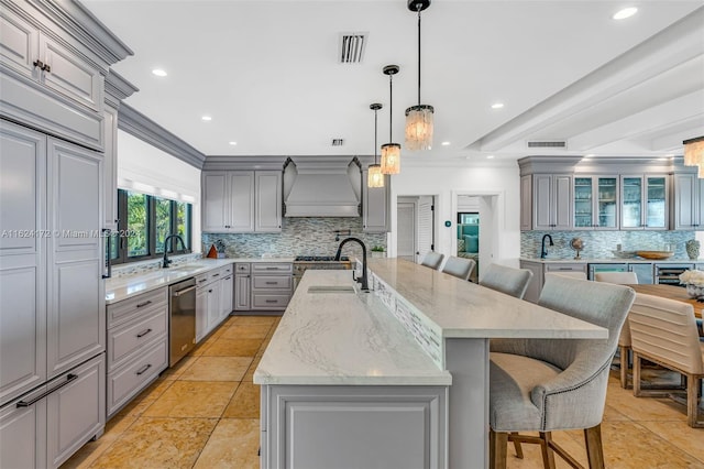 kitchen featuring gray cabinets, premium range hood, sink, and a spacious island