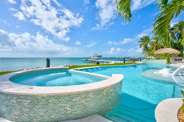 view of swimming pool with a water view and an in ground hot tub