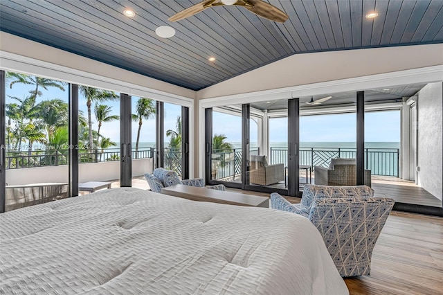 bedroom with wood ceiling, access to exterior, hardwood / wood-style floors, a water view, and vaulted ceiling