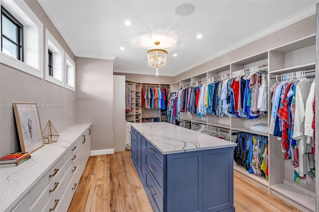 spacious closet featuring a notable chandelier and light hardwood / wood-style flooring