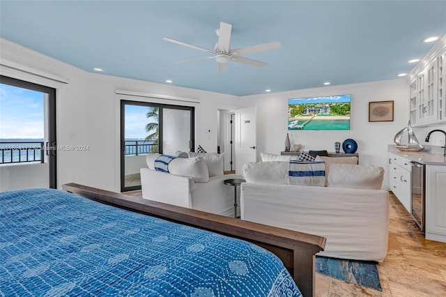 bedroom featuring a water view, ceiling fan, multiple windows, and access to outside