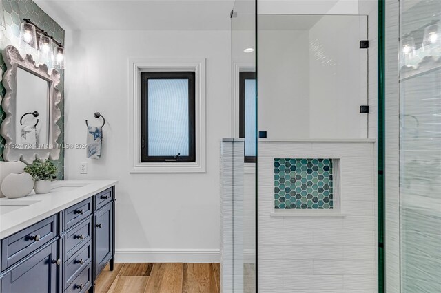 bathroom with vanity, an enclosed shower, and wood-type flooring