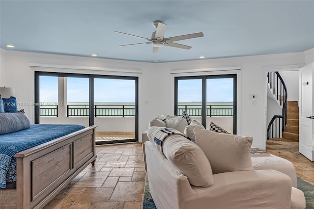 bedroom featuring a water view, access to exterior, and ceiling fan