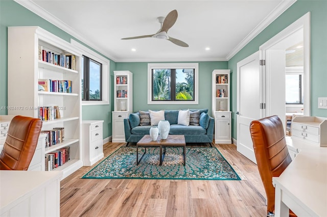 living room featuring ceiling fan, ornamental molding, and light hardwood / wood-style floors