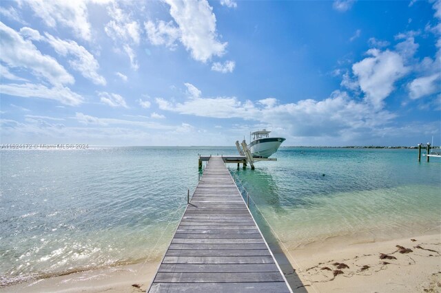 dock area with a water view and a beach view