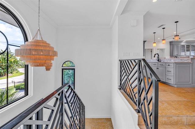 staircase featuring crown molding and sink