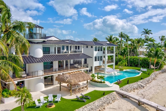 rear view of house with a bar, a balcony, a yard, and a patio area