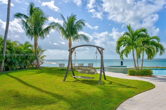 view of community featuring a lawn and a water view