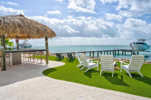 view of home's community with a yard, a patio, and a water view