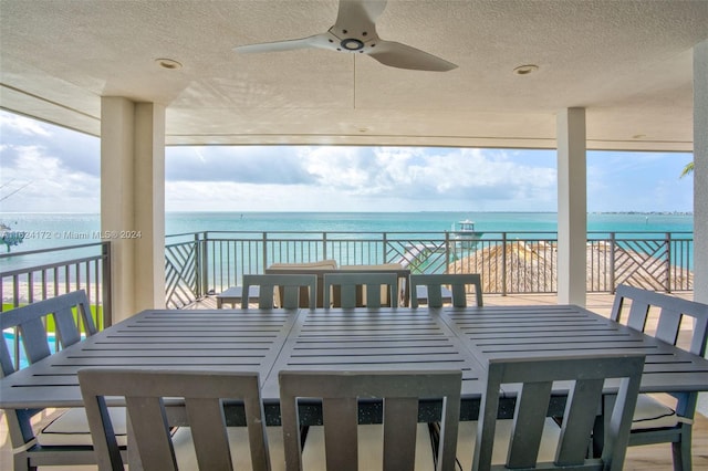 wooden terrace featuring a water view and ceiling fan