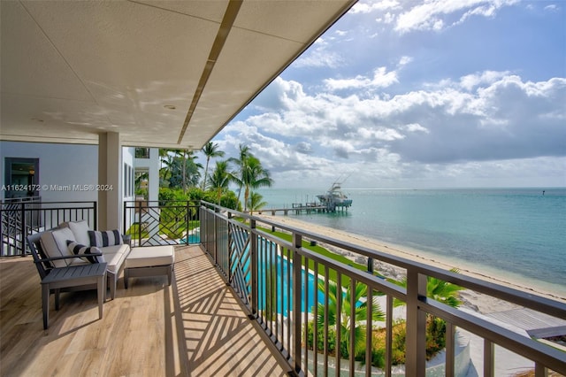 balcony featuring a water view and a beach view