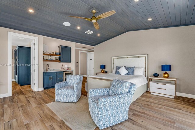 bedroom with wine cooler, lofted ceiling, light hardwood / wood-style floors, and indoor wet bar