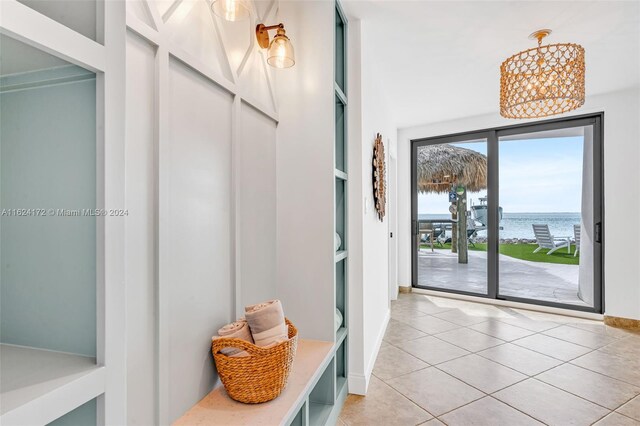 mudroom featuring a water view and light tile patterned flooring